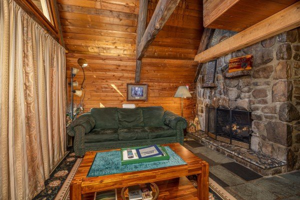 Sofa and fireplace at Ever After, a 1 bedroom cabin rental located in Gatlinburg