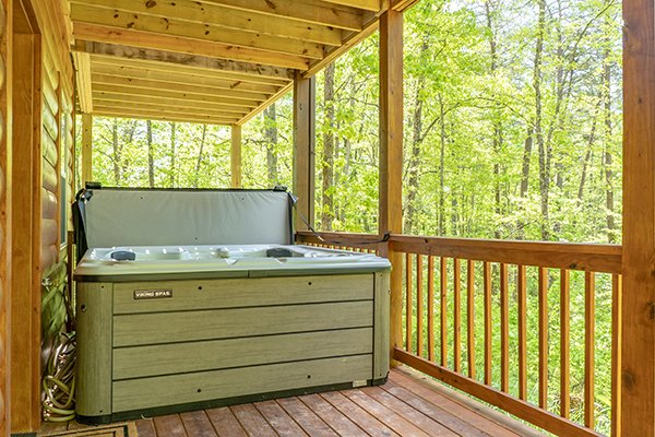 Hot tub on a covered deck at Relaxation Ridge, a 2 bedroom cabin rental located in Pigeon Forge