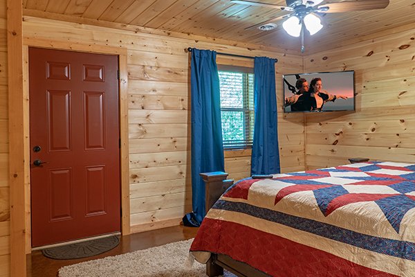 Bedroom with deck access & television at Relaxation Ridge, a 2 bedroom cabin rental located in Pigeon Forge