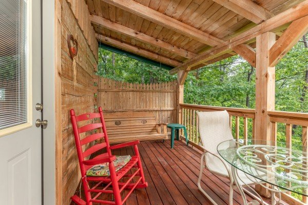 Deck with privacy fence, swing, rocking chair, and bistro set at Loving You, a 1 bedroom cabin rental located in Pigeon Forge