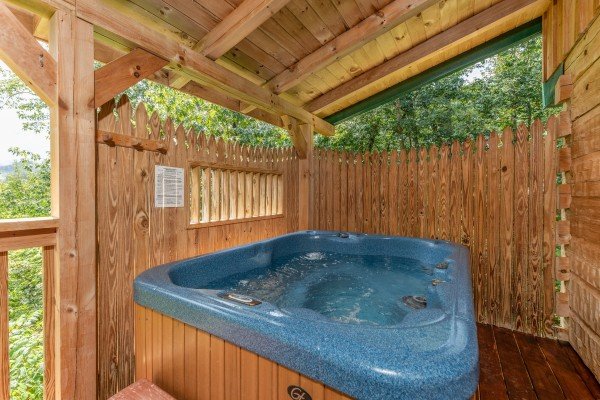 Hot tub and privacy fence on a covered deck at Loving You, a 1 bedroom cabin rental located in Pigeon Forge