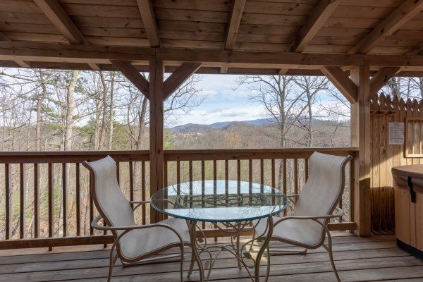 Outdoor dining table on a covered deck at Loving You, a 1 bedroom cabin rental located in Pigeon Forge