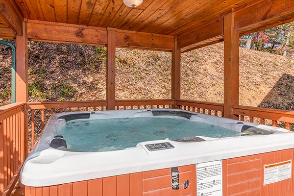 Hot tub on a covered deck at Rocky Top Lodge, a 3 bedroom cabin rental located in Pigeon Forge