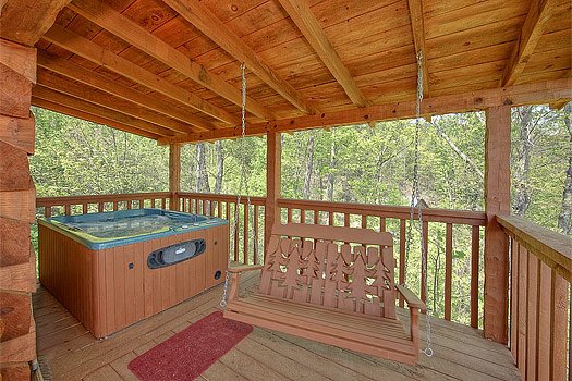 Covered deck with swing and hot tub at Do Not Disturb, a 1-bedroom cabin rental located in Pigeon Forge