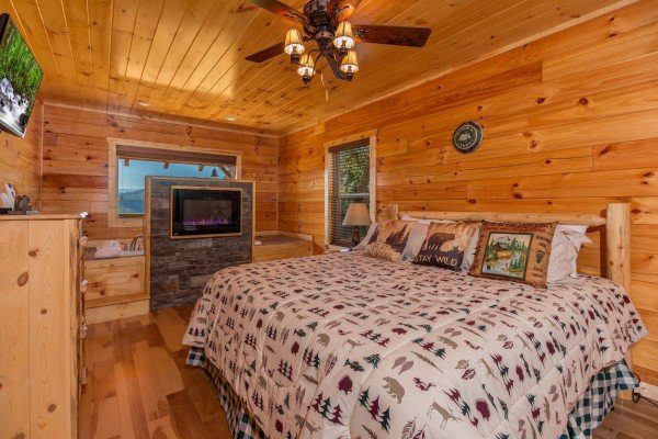 King bed and fireplace in a bedroom at Canyon Camp Falls, a 2 bedroom cabin rental located in Pigeon Forge