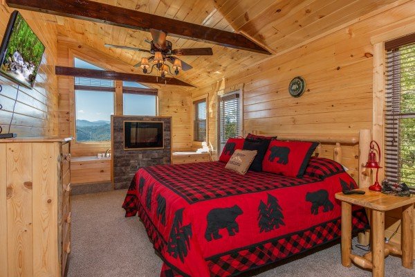 Bedroom with a king bed, fireplace, and TV at Canyon Camp Falls, a 2 bedroom cabin rental located in Pigeon Forge