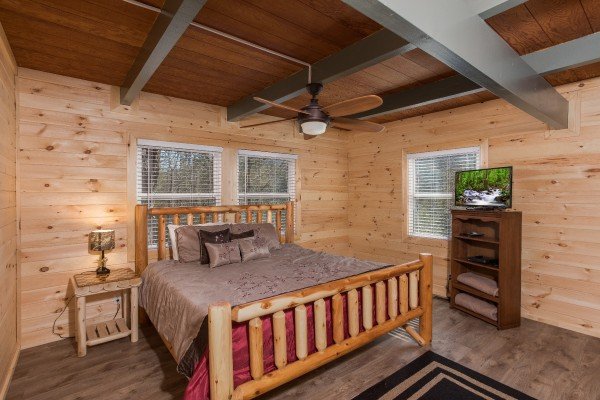 Bedroom with a log bed, night stand, and TV at Forever Country, a 3 bedroom cabin rental located in Pigeon Forge