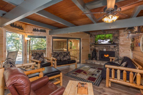 Living room with log furniture, fireplace, and TV at Forever Country, a 3 bedroom cabin rental located in Pigeon Forge