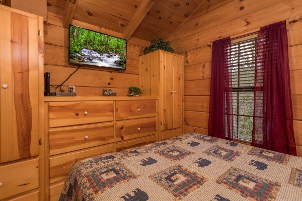Bedroom with a dresser, armoires, and television at Boogie Bear, a 1-bedroom cabin rental located in Gatlinburg