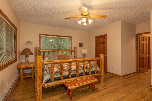 Bedroom with a log bed, two night stands, and a bench at Cubs' Crib, a 3 bedroom cabin rental located in Gatlinburg