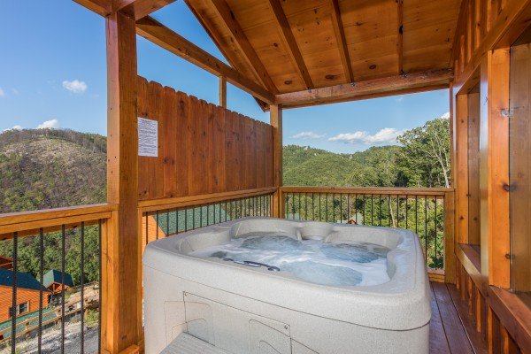 Hot tub on a covered deck at The Sugar Shack, a 2 bedroom cabin rental located in Pigeon Forge