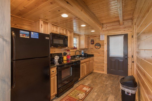 Kitchen with black appliances at The Sugar Shack, a 2 bedroom cabin rental located in Pigeon Forge