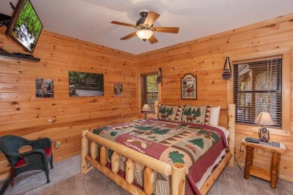 Bedroom with a king-sized log bed and TV at Great View Lodge, a 5-bedroom cabin rental located in Pigeon Forge