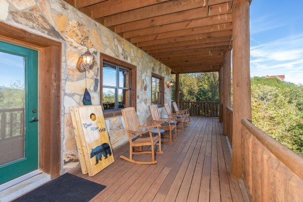 Deck with bean bag game and rocking chairs at Great View Lodge, a 5-bedroom cabin rental located in Pigeon Forge