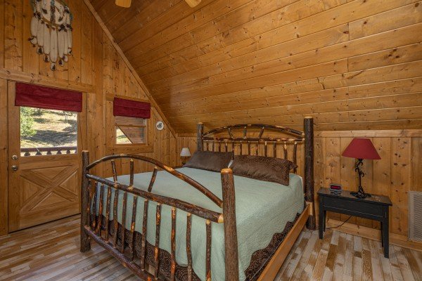 Bedroom with a wooden bed, end tables, and lamps at A Beary Nice Cabin, a 2 bedroom cabin rental located in Pigeon Forge