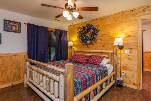 Bedroom with a log bed and lamps in cabin 1 at The Settlement, a 10 bedroom cabin rental located in Pigeon Forge