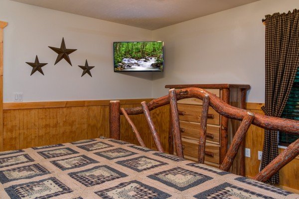 Dresser and TV in a bedroom at The Settlement, a 10 bedroom cabin rental located in Pigeon Forge