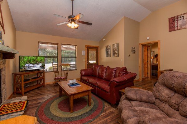 Living room with sofa, recliner, and TV at cabin 2 at The Settlement, a 10 bedroom cabin rental located in Pigeon Forge