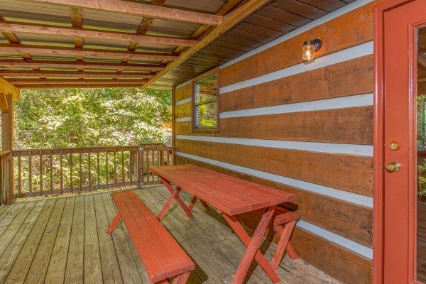 Picnic table on the porch of cabin 2 at The Settlement, a 10 bedroom cabin rental located in Pigeon Forge