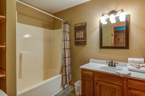 Bathroom with a tub and shower in cabin 2 at The Settlement, a 10 bedroom cabin rental located in Pigeon Forge