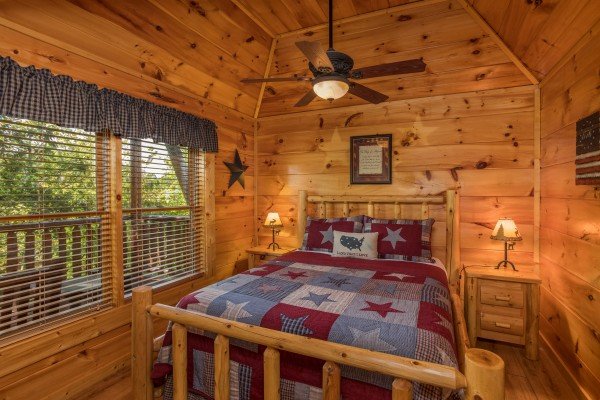 Bedroom with log bed, night stands, and lamps at Graceland, a 4-bedroom cabin rental located in Pigeon Forge