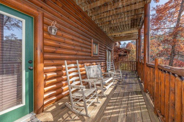 Rocking chairs and rocking bench on a covered deck at Loving Every Minute, a 5 bedroom cabin rental located in Pigeon Forge