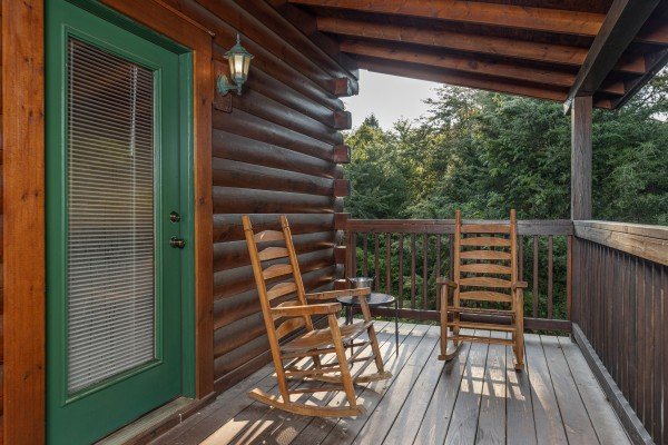 Rocking chairs on a covered deck at Family Getaway, a 4 bedroom cabin rental located in Pigeon Forge
