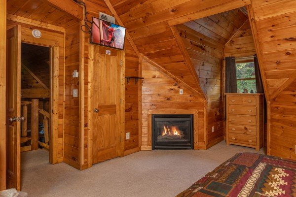 Fireplace and TV in a bedroom at Family Getaway, a 4 bedroom cabin rental located in Pigeon Forge