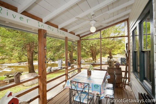 Patio dining on screened deck at Dolly's Adorable River Cottage, a 3-bedroom cabin rental located in Pigeon Forge