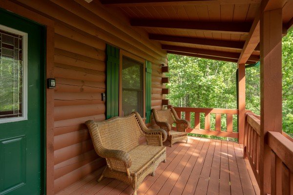 Wicker seating on the front porch at Mountain Breeze, a 1 bedroom cabin rental located in Pigeon Forge
