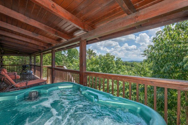 Hot tub on a covered deck at Top of the Way, a 2 bedroom cabin rental located in Pigeon Forge