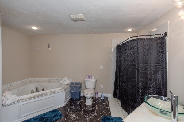 Bathroom with jacuzzi in the corner and a separate shower at Into the Woods, a 3 bedroom cabin rental located in Pigeon Forge