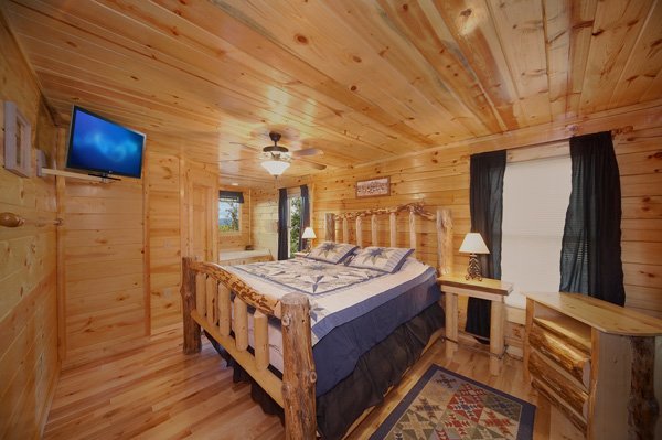 King-sized log bed at Bullwinkle's Place, a 1-bedroom cabin rental located in Gatlinburg