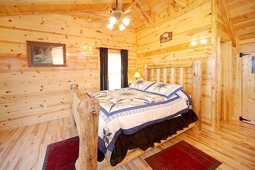 Queen log bed in lofted bedroom at Bullwinkle's Place, a 1-bedroom cabin rental located in Gatlinburg