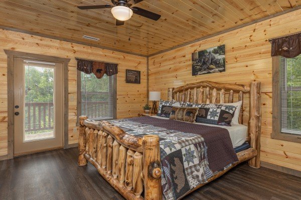 Bedroom with a king bed, night stand, lamp, and deck access at Alpine Adventure, a 4 bedroom cabin rental located in Pigeon Forge