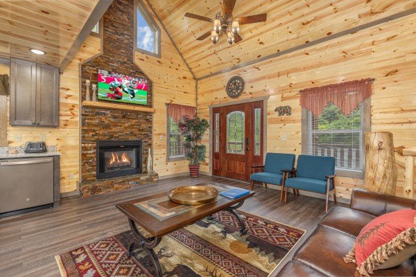Living room with fireplace, TV, and seating at Alpine Adventure, a 4 bedroom cabin rental located in Pigeon Forge