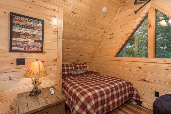 Queen bed in the loft space at Pigeon Forge Treehouse, a 1 bedroom cabin rental located in Pigeon Forge