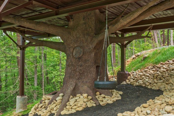 Tire swing mounted under the cabin at Pigeon Forge Treehouse, a 1 bedroom cabin rental located in Pigeon Forge