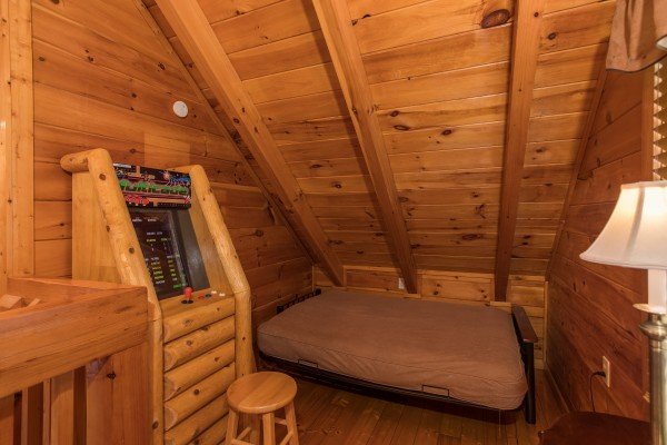 Arcade and bed in the loft space at 5 Star Celebration, a 1 bedroom cabin rental located in Pigeon Forge