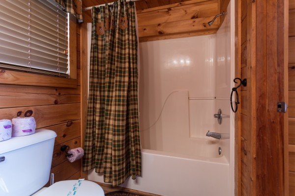 Bathroom with a tub and shower at 5 Star Celebration, a 1 bedroom cabin rental located in Pigeon Forge