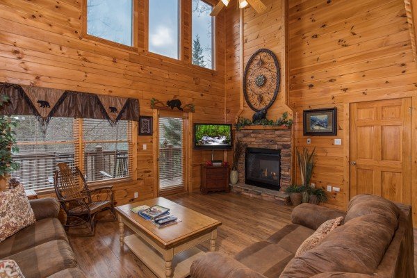 Living room with fireplace and TV at 5 Star Celebration, a 1 bedroom cabin rental located in Pigeon Forge