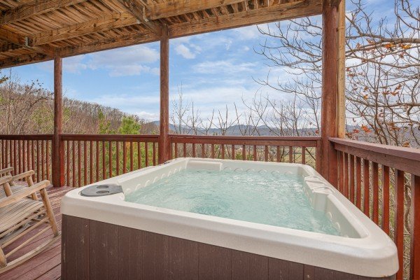 Hot tub on a covered deck at Hummingbird's Views, a 1 bedroom cabin rental located in Pigeon Forge