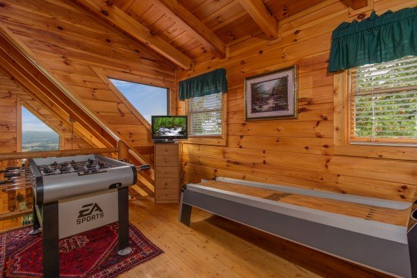 Foosball, skeeball, and a TV in the loft at Hummingbird's Views, a 1 bedroom cabin rental located in Pigeon Forge