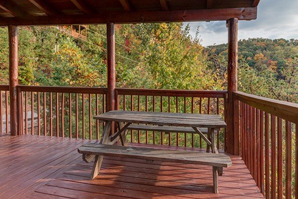 Picnic table on a covered deck at Hummingbird's Views, a 1 bedroom cabin rental located in Pigeon Forge