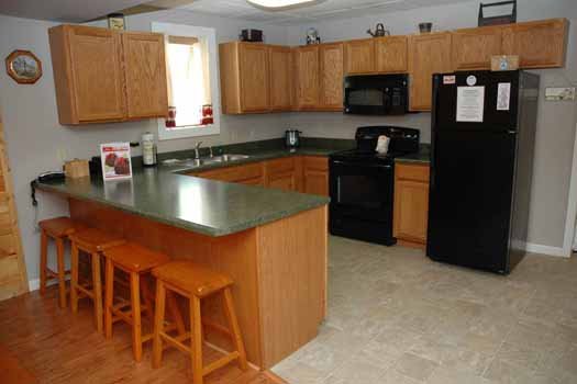 Kitchen with counter seating for four and black appliances at Heaven Sent, a 2-bedroom cabin rental located in Pigeon Forge