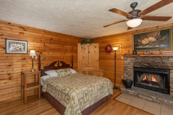 Bedroom with a four post bed and in room fireplace at Hideaway, a 1 bedroom cabin rental located in Pigeon Forge