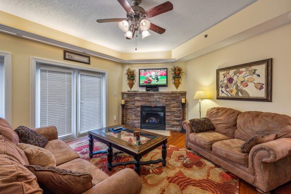 Living room with sofa, loveseat, TV, and fireplace at Heart of Gatlinburg, a 2 bedroom cabin rental located in Gatlinburg