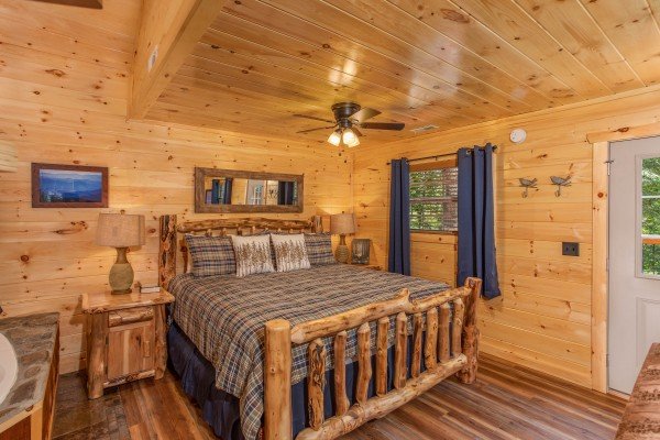King sized log bed on the studio style main floor at Out on a Limb, a 1 bedroom cabin rental located in Gatlinburg