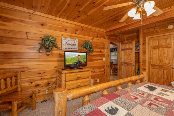 TV, dresser, and chair in a bedroom at Alpine Tranquility, a 4 bedroom cabin rental located in Pigeon Forge