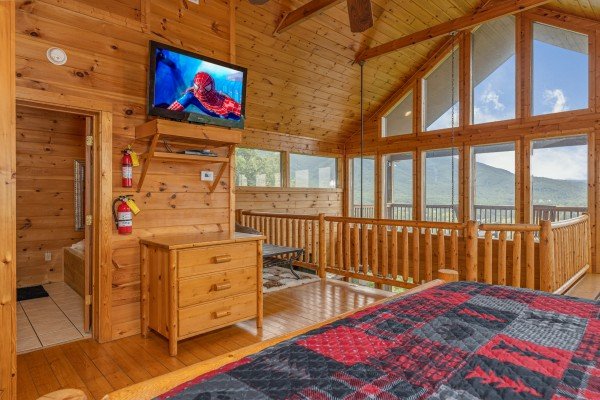Dresser, TV, en suite bath, and catwalk in the bedroom at 1 Awesome View, a 3 bedroom cabin rental located in Pigeon Forge